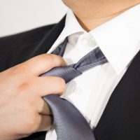 スーツのネクタイを緩める男性