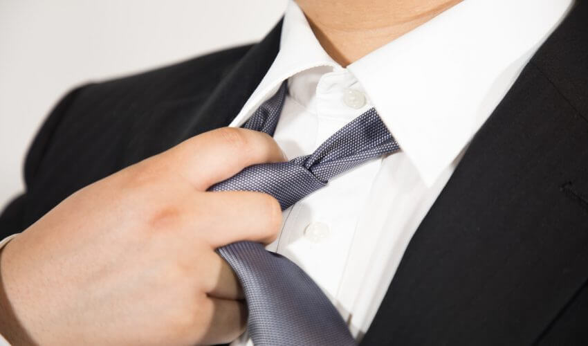 スーツのネクタイを緩める男性
